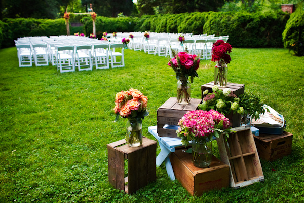 ceremony decor - assorted fruit crates decorated with orange, dark pink, and red bouquets - photo by Washington DC based wedding photographers Holland Photo Arts